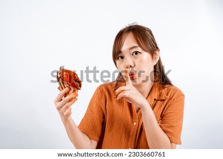 young asian woman enjoys eating seafood, crab with padang sauce (Indonesian : Kepiting Saus Padang) isolated on white background