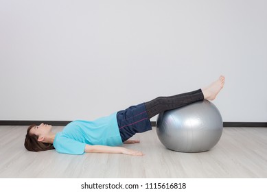 Young Asian Woman Exercising With Balance Ball.