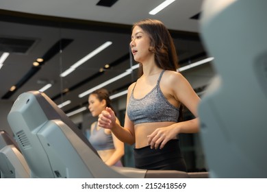 Young Asian Woman Exercising On  Treadmill At A Gym.Active People Running On Treadmill. Smile And Funny Emotion.