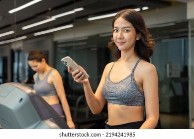 Young Asian Woman Exercising On  Treadmill At A Gym.Active People Running On Treadmill. Smile And Funny Emotion.