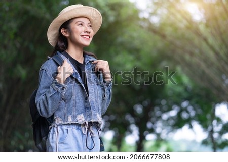 Young Asian woman explores the forest on holiday