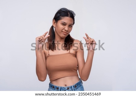 A young asian woman expressing something tiny or little with both thumbs and index fingers, looking unimpressed or condescending. Describing a small package. Isolated on a white background.