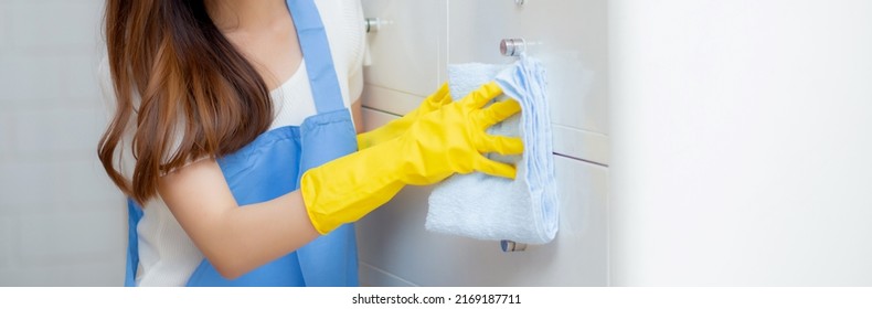 Young asian woman in face mask and gloves cleaning home in room, housekeeper is wipe with fabric, housemaid and service, worker polish dust, housework and domestic, lifestyle concept, banner website.