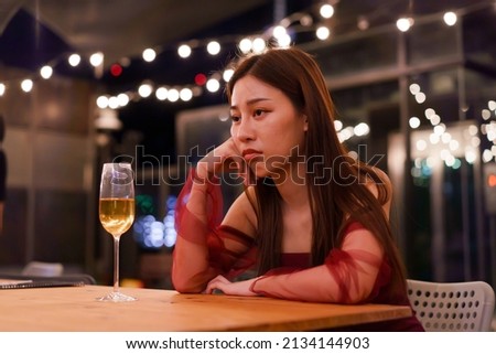 Young Asian woman feeling sad and heartbroken after breaking up with her boyfriend while sitting at restaurant