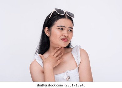 A young asian woman feels thirsty. Touching her parched throat. Isolated on a white background.