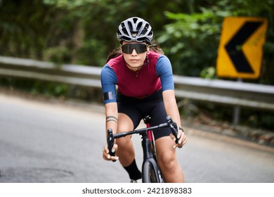 young asian woman female cyclist riding bicycle outdoors on rural road - Powered by Shutterstock