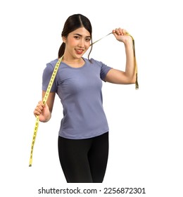 Young Asian woman in fitness clothes holding a measuring tape with a smile. Portrait on white background with studio light. Healthy nutrition and weight losing concept. - Shutterstock ID 2256872301