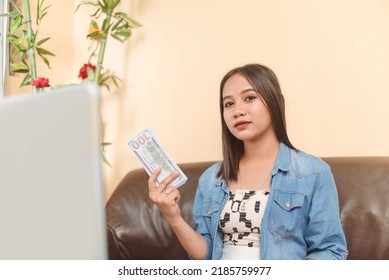 A Young Asian Woman Flaunting Money. Flashing The Paper 100 Dollar Bills. Making Money Through An Online Business Venture. A Working Woman Showing Her Hard Earned Wealth.