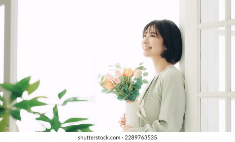 Young Asian woman with flowers.  flower arrangement. - Powered by Shutterstock