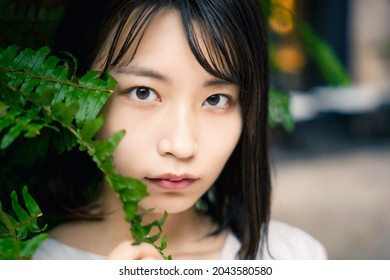 Young asian woman in front of plants. Botanical cosmetics. Skin care.