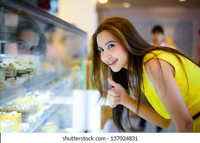 Young Asian Woman In Front Of Sweet Candy Food Store Window