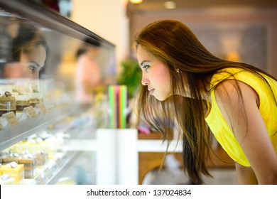 Young Asian Woman In Front Of Sweet Candy Food Store Window