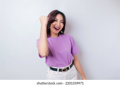 A Young Asian Woman With A Happy Successful Expression Wearing Lilac Purple Shirt Isolated By White Background