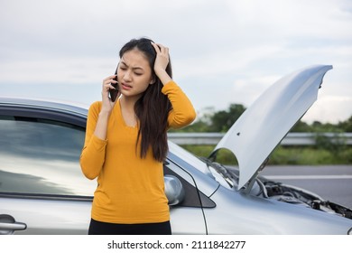 Young Asian Woman Has Broken Down Car On The Road She Feeling Serious And Stressed. Look For Someone Help. Using Smartphone Call Emergency Assistance Or Insurance Service.