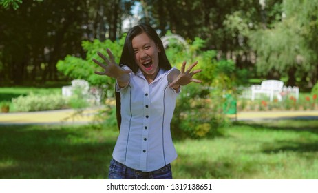 Young asian woman have fun. Portrait beautiful girl frightening. Female shows how she make afraid people. Beautiful model smile at the camera wearing in casual white shirt.