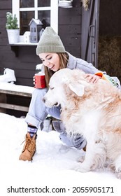 Young Asian Woman Having Fun With Labrador Retriever Dog Near Porch In Courtyard Of Suburban House In Winter, Concept Of Christmas And New Year Vacation On Farm, Family Love And Support