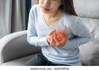 Young Asian Woman Having A Pain In The Heart Area. Female Suffering From Heart Ache Painful Chest. Health Care, Medical Concept. 