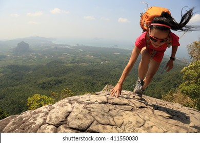 Young Asian Woman Hiker Climbing Rock On Mountain Peak Cliff