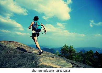 Young Asian Woman Hiker Running On Mountain Peak Cliff