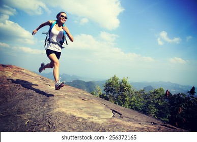 Young Asian Woman Hiker Running On Mountain Peak Cliff