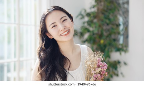 Young asian woman holding bouquet. Beauty concept. Skin care. Body care. - Powered by Shutterstock