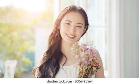 Young asian woman holding bouquet. Beauty concept. Skin care. Body care. - Powered by Shutterstock