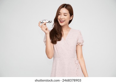 Young Asian woman holding car model isolated on white background, Car Insurance concept - Powered by Shutterstock