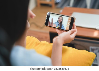 Young Asian Woman Was Holding A Cell Phone And Video Conference To Say Hi And Care To Family And Friends.