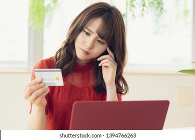 Young asian woman holding a credit card.