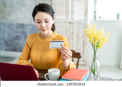 Young asian woman holding a credit card.
