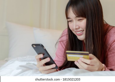 Young Asian woman holding credit card and using smartphone. Online shopping, e-commerce, internet banking, spending money, working from home concept. - Shutterstock ID 1815021203