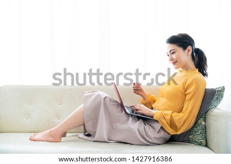 Young asian woman holding a credit card and a laptop.