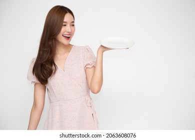 Young Asian Woman Holding Empty White Plate Or Dish Isolated On White Background