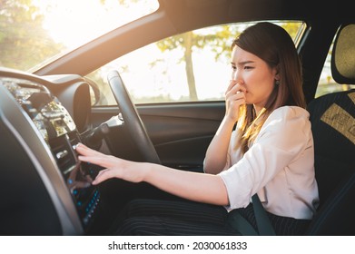 Young Asian woman holding her nose because of bad smell after turn on car air conditioning - Shutterstock ID 2030061833