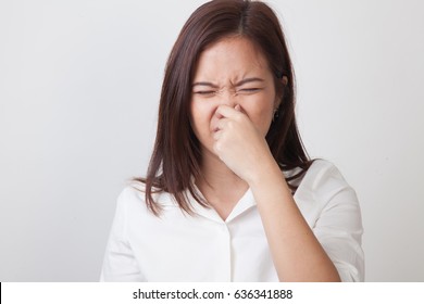 Young Asian Woman  Holding Her Nose Because Of A Bad Smell On White Background