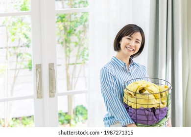 Young Asian Woman Holding A Laundry Basket.