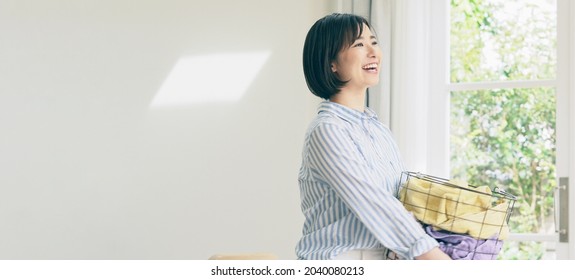 Young Asian Woman Holding A Laundry Basket.