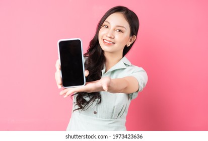 Young Asian woman holding phone in hand and holding it forward
