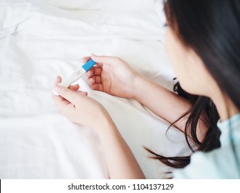 Young Asian Woman Holding Pregnancy Test In Hands.
