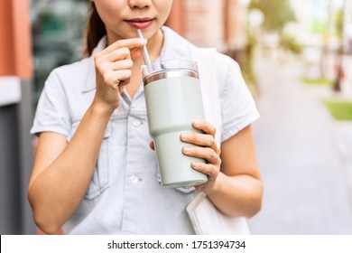 Young asian woman holding a reusable tumbler glass and walking in the city, Zero waste concept
