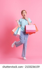 Young Asian Woman Holding Shopping Bag On Pink Background