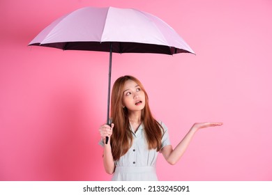 Young Asian Woman Holding Umbrella On Pink Background