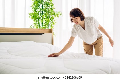 Young asian woman housewife clean bed and set up changing bedsheet with white clean sheet tidy up bedroom.room service and cleaning concept - Shutterstock ID 2142208689