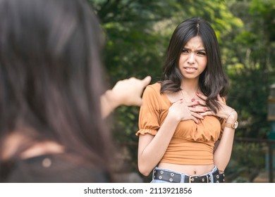 A young asian woman is insulted by accusations hurled on her by another girl. Standoff at a park.