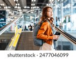 Young asian woman in international airport terminal or modern train station. Backpacker passenger female commuter walking on escalator