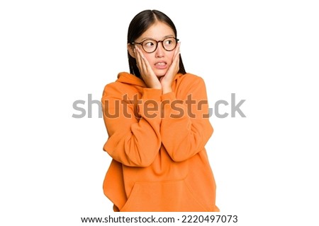 Young Asian woman isolated on green chroma background scared and afraid.
