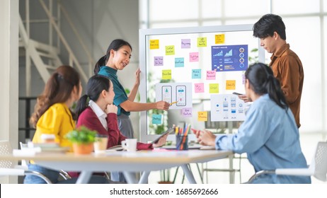 Young Asian Woman Leading Business Creative Team In Mobile Application Software Design Project. Brainstorm Meeting, Work Together, Internet Technology, Girl Power, Office Coworker Teamwork Concept