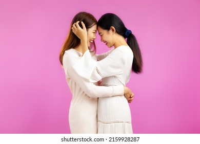 Young asian woman lesbian couple in white dress posing hug in concept of lgbtq couple on the pink screen background. Pr1de - Powered by Shutterstock