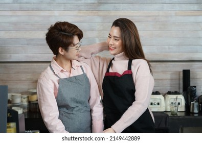 young asian woman LGBTQ lover talking and smiling together happily in business owner coffee shop. concept for LGBTQ lifestyle, cohabitation, relationship etc   