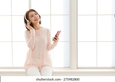 Young Asian Woman Listening Music